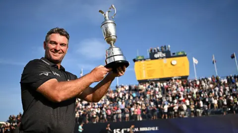 Ryan Fox lifts Claret Jug in front of a Royal Birkdale scoreboard