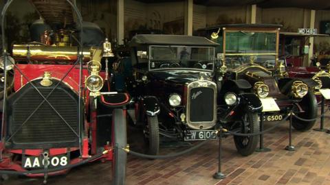 A display of four vintage cars at the National Motor Museum