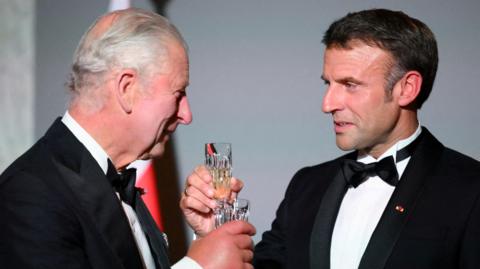 French President Emmanuel Macron toasts with Britain's King Charles during a state banquet at the Palace of Versailles, west of Paris, on September 20, 2023, on the first day of a British royal state visit to France.
