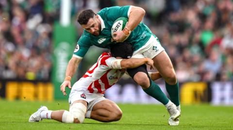 Ireland centre Robbie Henshaw is tackled