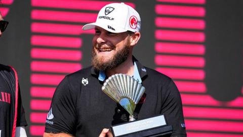 Tyrrell Hatton smiles as he holds the trophy for winning in Andalucia