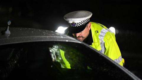 A police officer speak to a drug driver