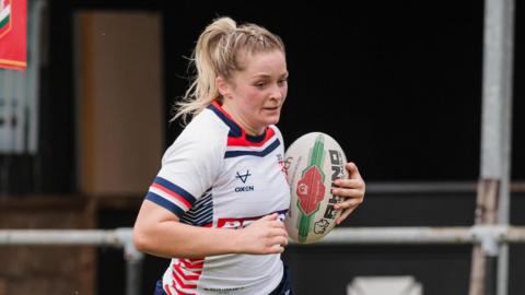 Eboni Partington, playing for England, with the ball under her left arm
