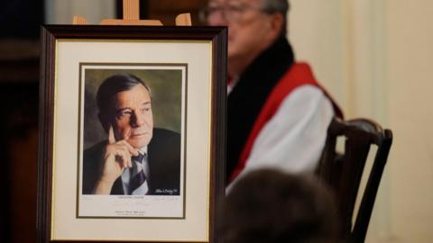 A photo of Dickie Bird placed at the front of a church as his funeral service is held