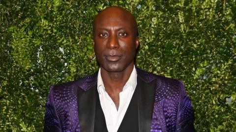 A heads-and-shoulder shot of Ozwald Boateng in a purple jacket in 2024