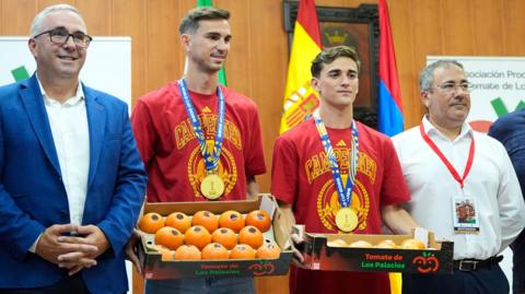 Spain midfielders Fabian Ruiz and Gavi holding a box of tomatoes on a visit back to the hometown of Los Palacios y Villafranca
