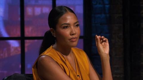 Guest Dragon Emma Grede on Dragon's Den looking at a contestant and their pitch with a stern look