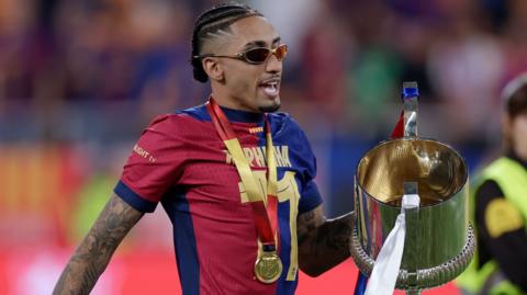 Raphinha of Barcelona celebrates the victory with the trophy after the Spanish Copa del Rey final against Real Madrid