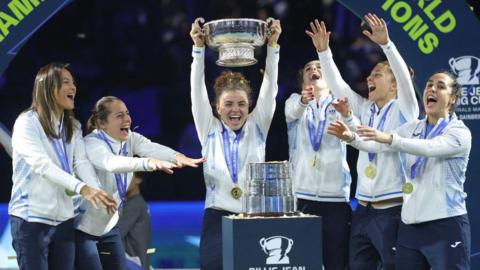 Italy's Jasmine Paolini (centre) celebrates with the trophy and Team Italy teammates after defeating Slovakia's Rebecca Sramkova