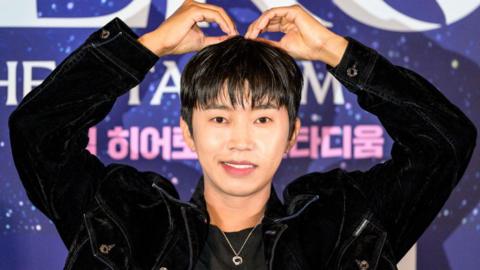 Lim Young-woong gestures a heart shape with both of his arms raised above his head