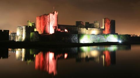 Caerphilly Castle illuminated at night.