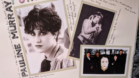 A scrapbook page with Pauline Murray's name drawn in bold letters down the left side of the page. There are three photos of Pauline Murray on the page, one a black and white portrait on the left, another black and white photo of her on stage singing into a microphone. Another shows her staring into the camera with four men standing behind her. 