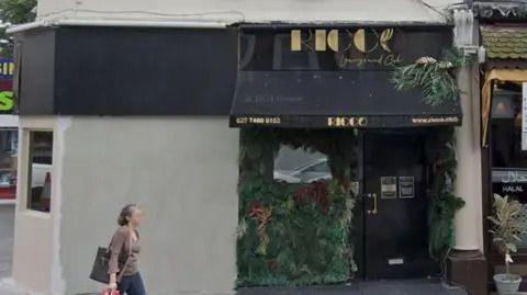 The outside of Ricco nightclub with a black sign and canopy saying Ricco in gold. 