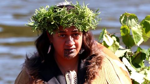 Head and shoulders shot of Maori Queen Kuini Ngā Wai hono i te pō wearing a wreath on her head while standing outside at her father's funeral in News Zealand on 5 September