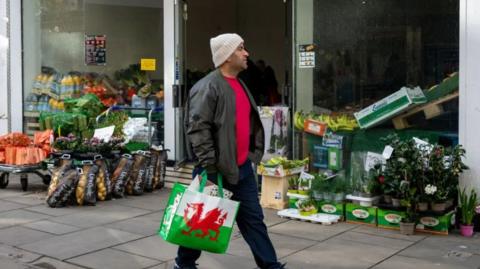 Shopper holding a bag with Welsh flag