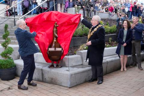 Bronze statue of Feathers McGraw from Wallace and Gromit. To the left is creator Nick Park and to the other side is Mayor of Preston Councillor Philip Crowe.