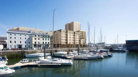 A view from across the harbour of the modern brown complex with boats in front.