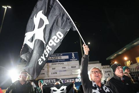 A supporter waves an Ospreys flag