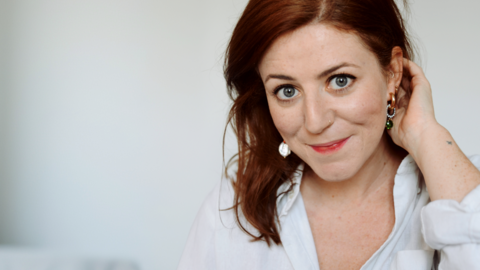  Catriona Byers has red hair and is wearing a white shirt. She is pictured against a white background.