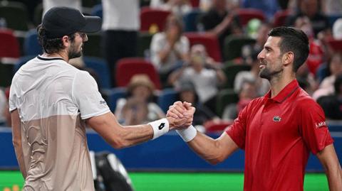 Valentin Vacherot shakes hands with Novak Djokovic