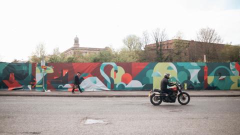 A digital mural in Piccadilly, York, showcasing the River Foss' historic influence in York with images of swans, ducks, boats and buildings. 