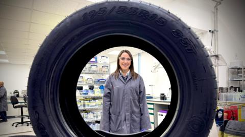 Ellie Galanis, a scientist at Levidian, is in a lab, looking through the centre of a car tyre which has had graphene added to it