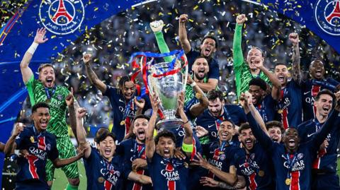 Paris St-Germain players celebrate with the Champions League trophy