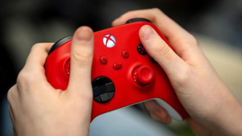 Hands holding a red Xbox controller