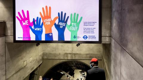 A poster with hands up saying "we won't stand for abuse of TfL staff"