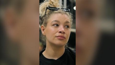 Molly looks unimpressed - she has blonde hair tied up and glasses on top of her head