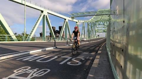 Man riding bicycle on recently installed cycle route on the Jubilee Bridge, Runcorn