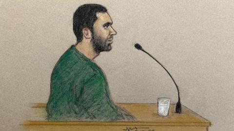 Sketch of Marcus Monzo, who is pictured sitting in the dock of the Old Bailey, behind a microphone, wearing a green jumper.