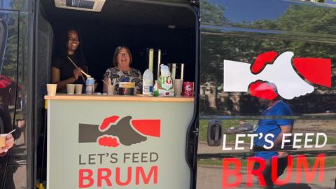 A young woman and an older woman smile at the camera. They stand behind a counter in a van and serve drinks. A logo on the van and the counter shows two hands grasping each other above the words 'Let's Feed Brum'.
