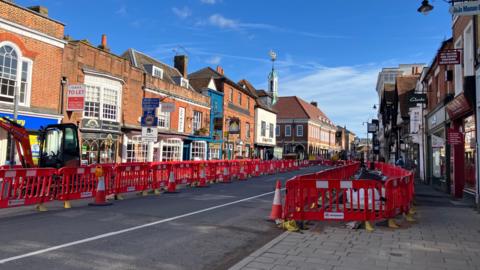 A wide view of The Borough in Farnham, with the pavements sealed off by red plastic rails.