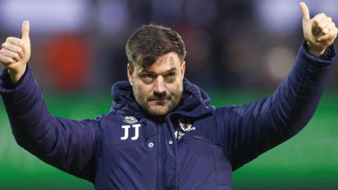 Wimbledon boss Johnnie Jackson gives a thumbs-up to the fans after the 3-1 win at Barrow