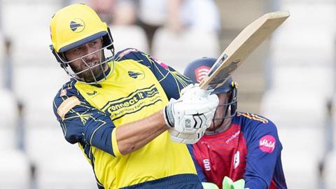 James Vince wearing a yellow Hampshire shirt plays a pull shot