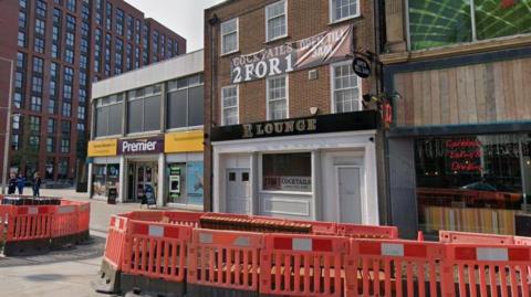 Frontage of the R Lounge in Derby with red barriers in the front of picture where roadworks are taking place.