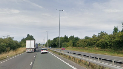 A Google Streetview image of the A610, a duel carriageway with grass either side and a metal railing in the central reservation.