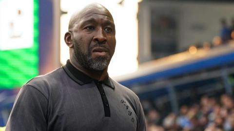 Darren Moore walks towards the dressing room along the touchline during a match