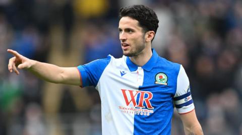 Blackburn Rovers captain Lewis Travis pointing to a team-mate.