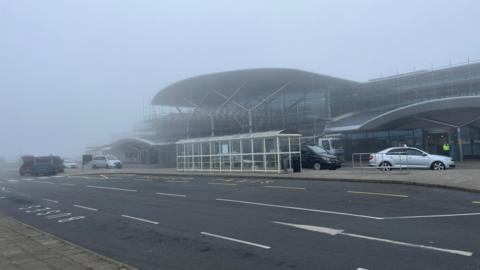 Photo of taxis waiting outside a very foggy Guernsey Airport