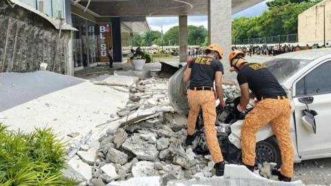 fire officers removing debris outside a shopping mall following an earthquake in Butuan city, Caraga region, Philippines, 10 October 2025. 