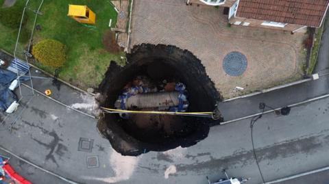 An aerial image of the 10 metre wide and 14 metre deep sinkhole at the end of a drive Nant Morlais in Pant.
