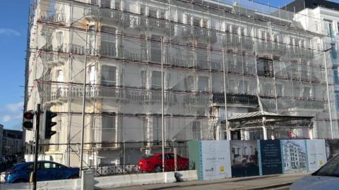White hotel building covered in scaffolding