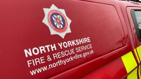 A red fire engine with the logo of North Yorkshire Fire & Rescue Service on the side