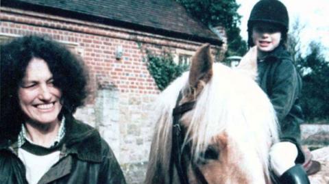 Dr Lin and daughter Megan Russell. Megan is sat on a horse