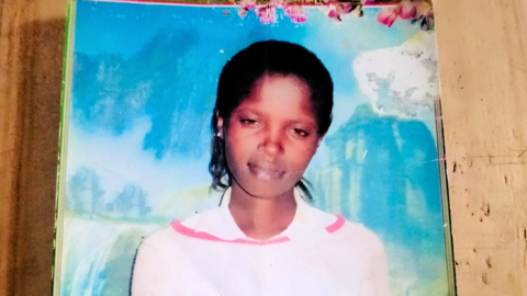 A photo of Agnes Wanjiru wearing a pink fleece top against a blue background.