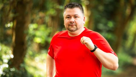 A man running in a wooded area