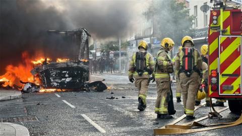 Firefighters tending to a burning bus