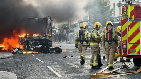 Firefighters tending to a burning bus